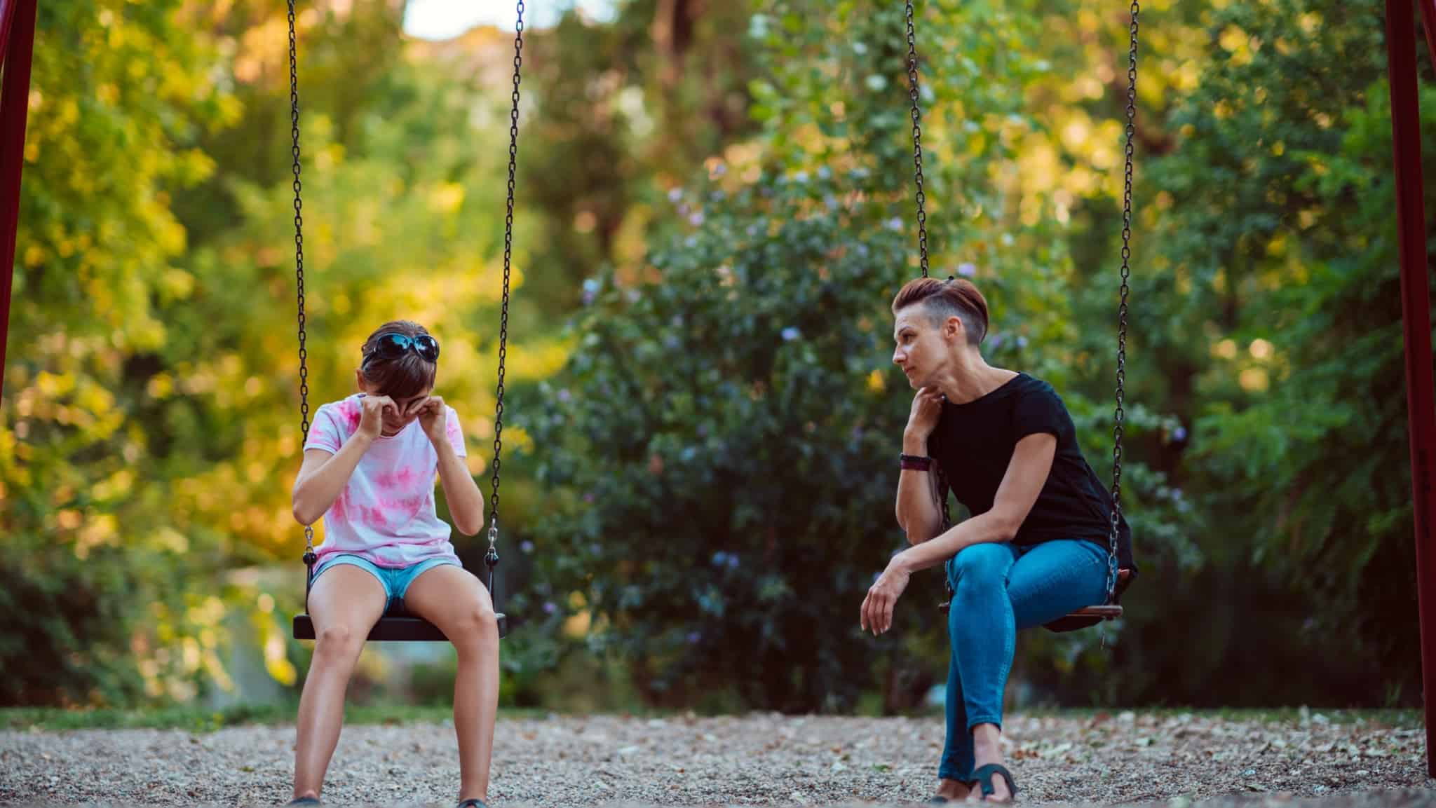 Så här kan du upptäcka om ditt barn eller tonåring är deprimerad. Bilden visar en mamma med sitt barn som sitter på en varsin gunga i en lekpark