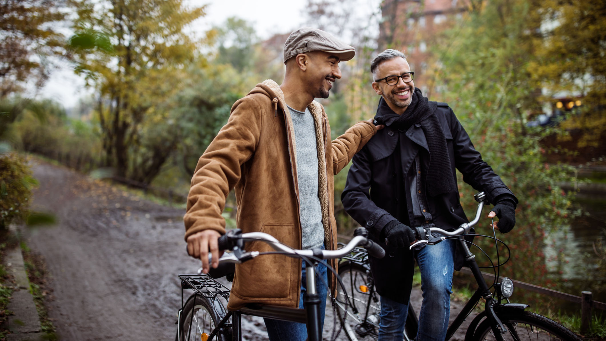 Vardagsdepp eller depression - när är det dags att söka hjälp? Två vänner står bredvid varandra med varsin cykel och pratar glatt med varandra